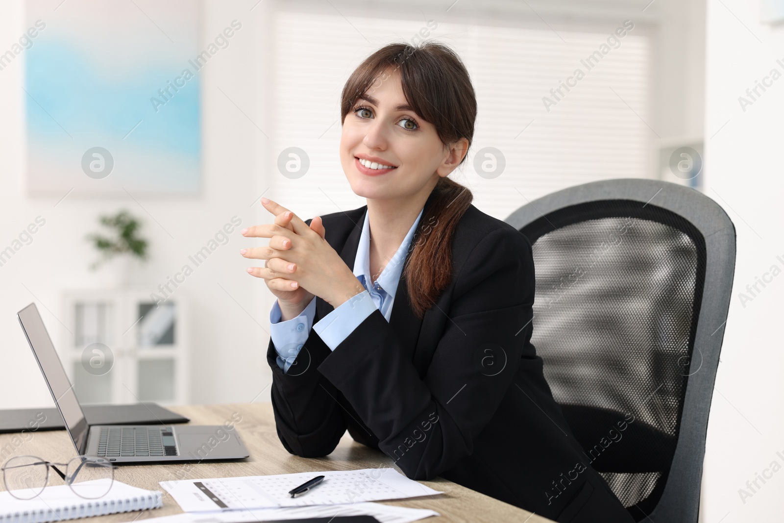 Photo of Portrait of smiling secretary at table in office