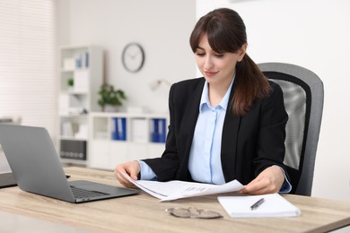 Secretary doing paperwork at table in office
