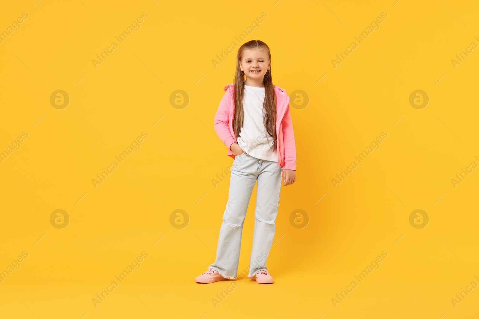 Photo of Cute little dancer posing on yellow background