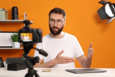 Technology blogger explaining something while recording video at home