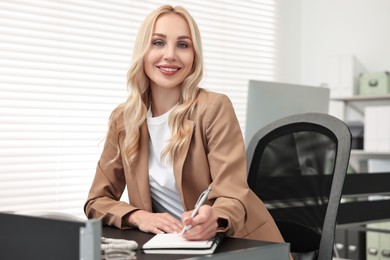 Photo of Secretary taking notes at table in office