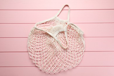 White string bag on pink wooden table, top view