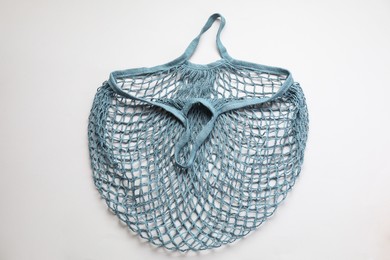 Blue string bag on light grey background, top view