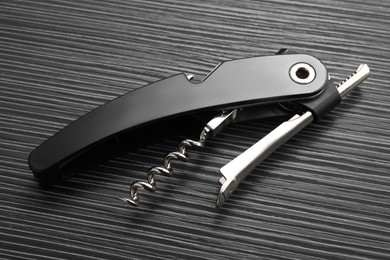 One corkscrew (sommelier knife) on black wooden table