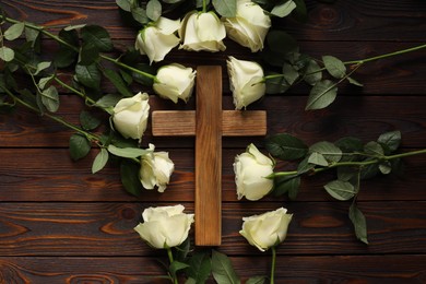 Cross and roses on wooden table, top view. Religion of Christianity