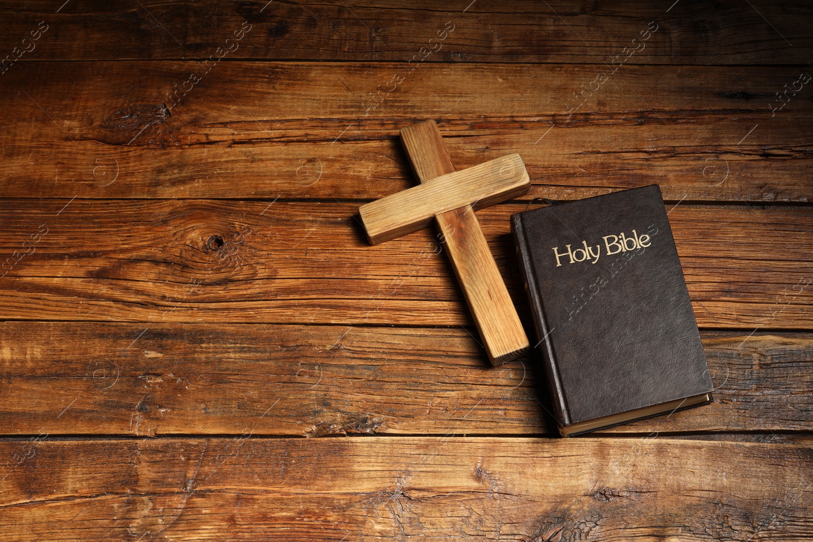 Photo of Bible and cross on wooden table, flat lay with space for text. Religion of Christianity