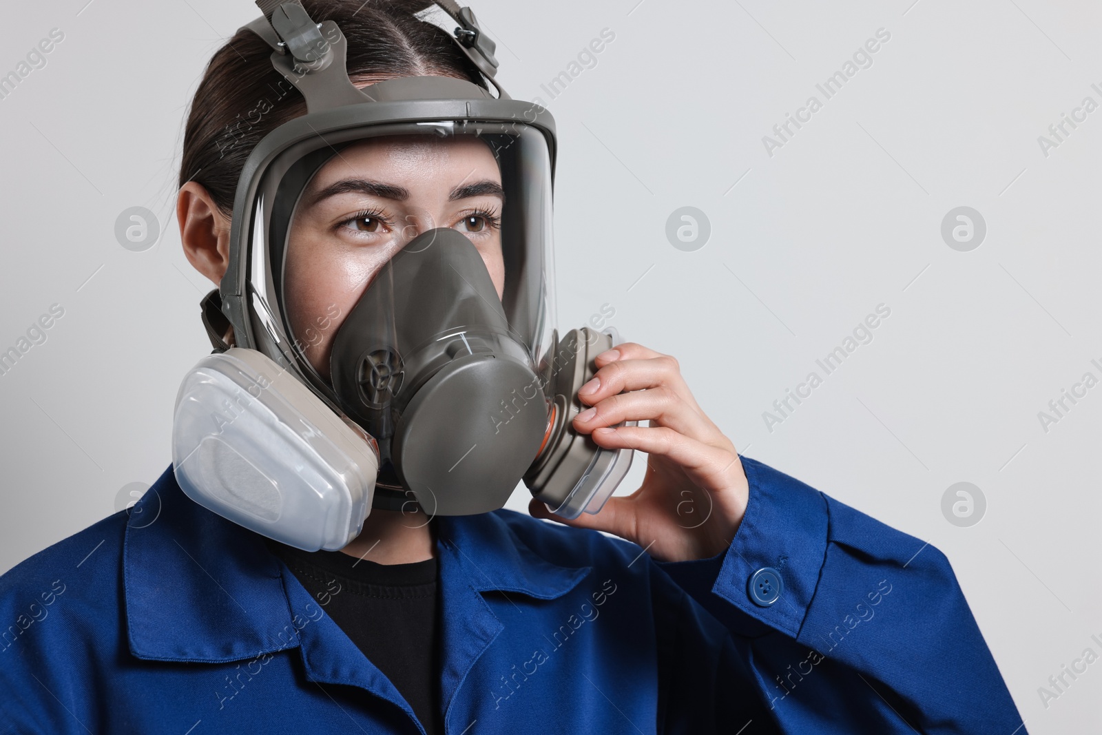 Photo of Worker in respirator mask on grey background