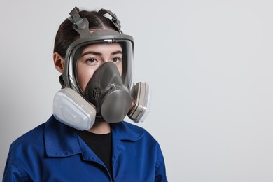 Photo of Worker in respirator on grey background, space for text