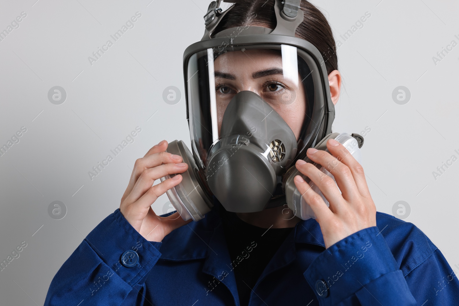 Photo of Worker in respirator mask on grey background