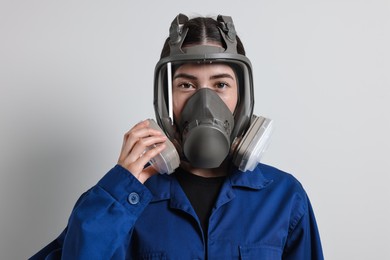 Photo of Worker in respirator mask on grey background