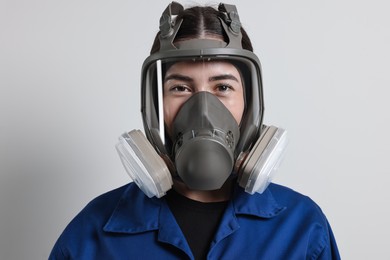 Worker in respirator mask on grey background