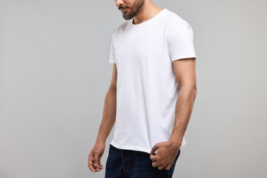 Photo of Man in white t-shirt on grey background, closeup