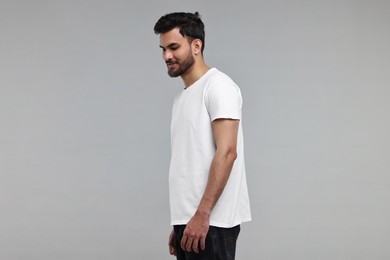 Photo of Handsome man in white t-shirt on grey background