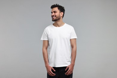 Smiling man in white t-shirt on grey background