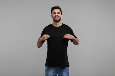 Smiling man in black t-shirt on grey background