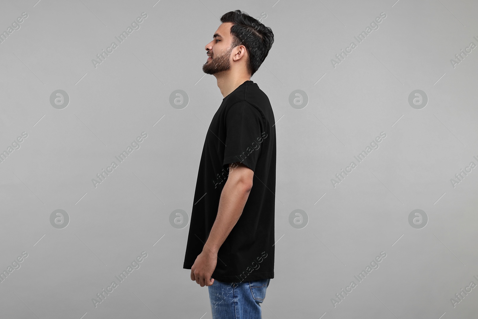 Photo of Smiling man in black t-shirt on grey background