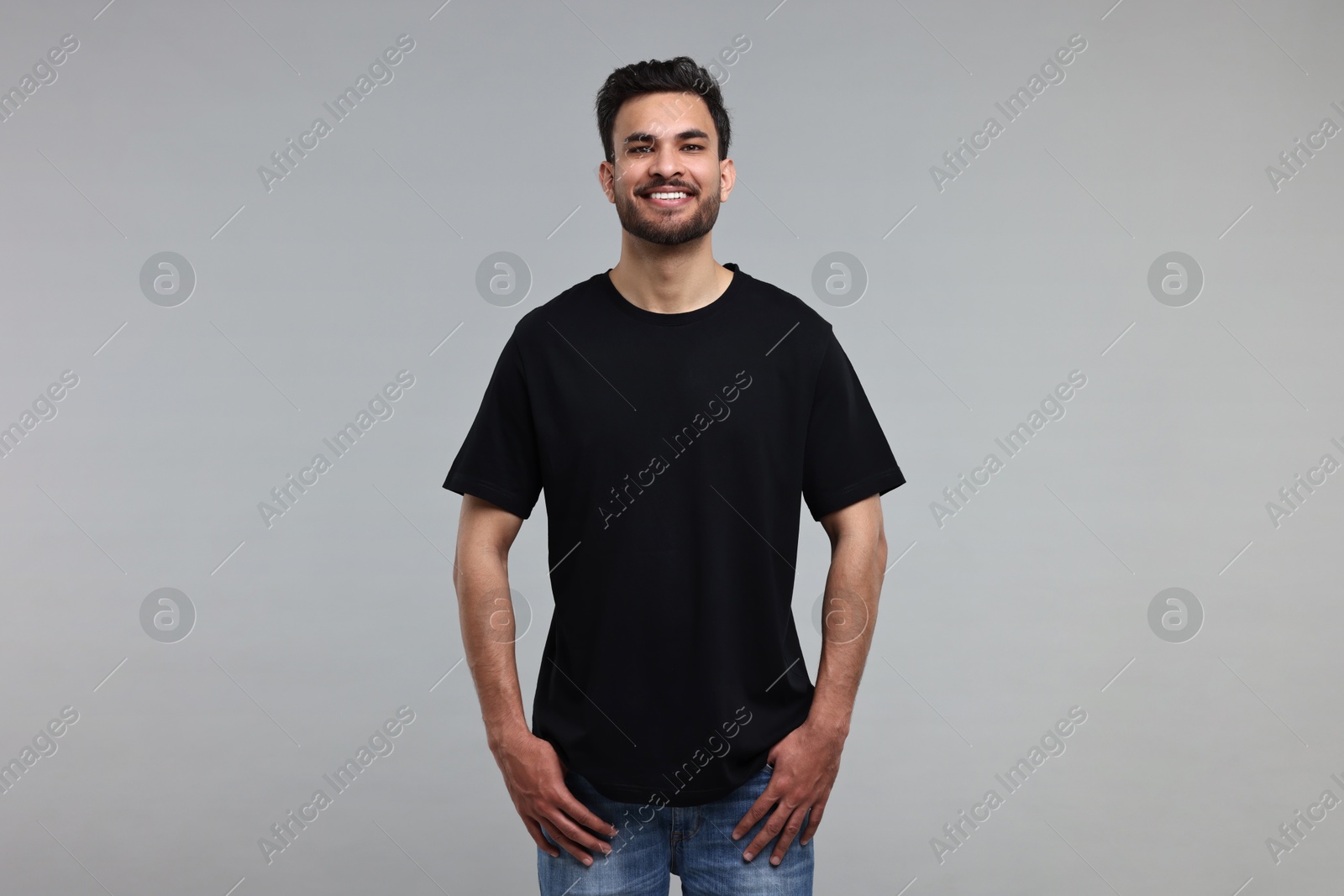 Photo of Smiling man in black t-shirt on grey background