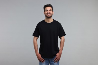 Photo of Smiling man in black t-shirt on grey background