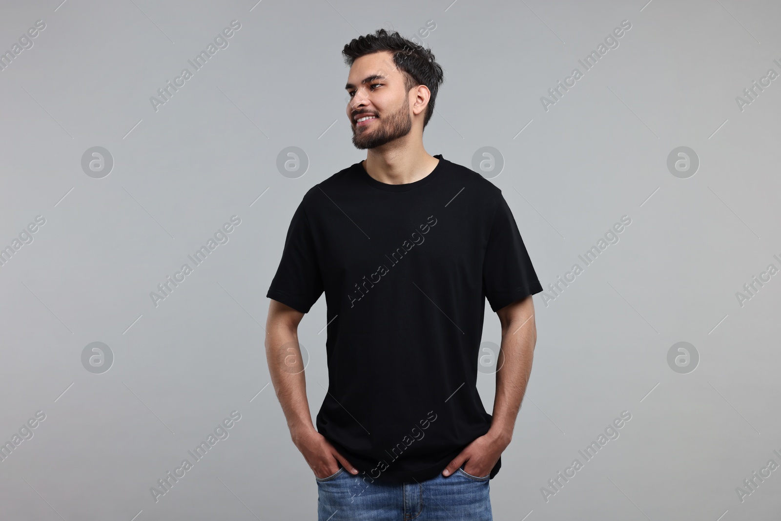 Photo of Smiling man in black t-shirt on grey background