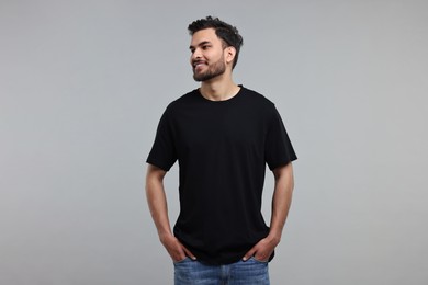 Smiling man in black t-shirt on grey background