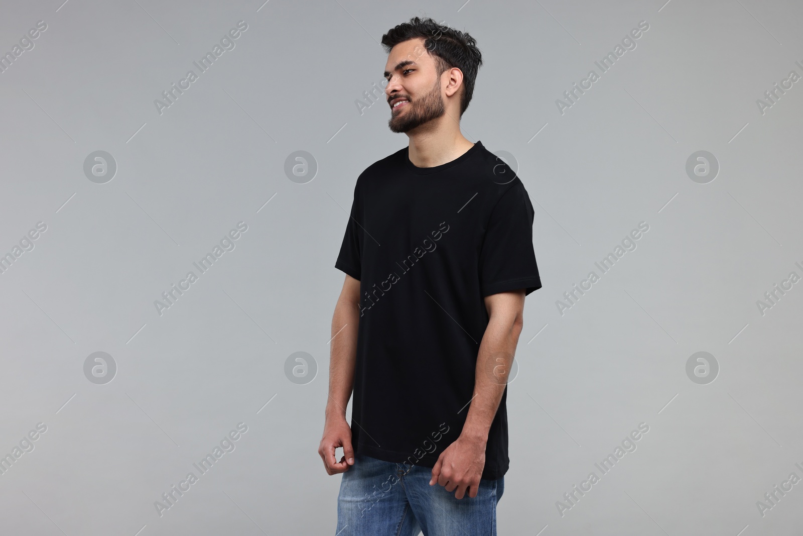 Photo of Smiling man in black t-shirt on grey background