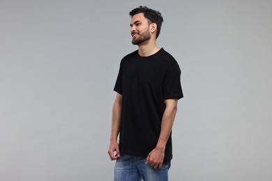 Photo of Smiling man in black t-shirt on grey background