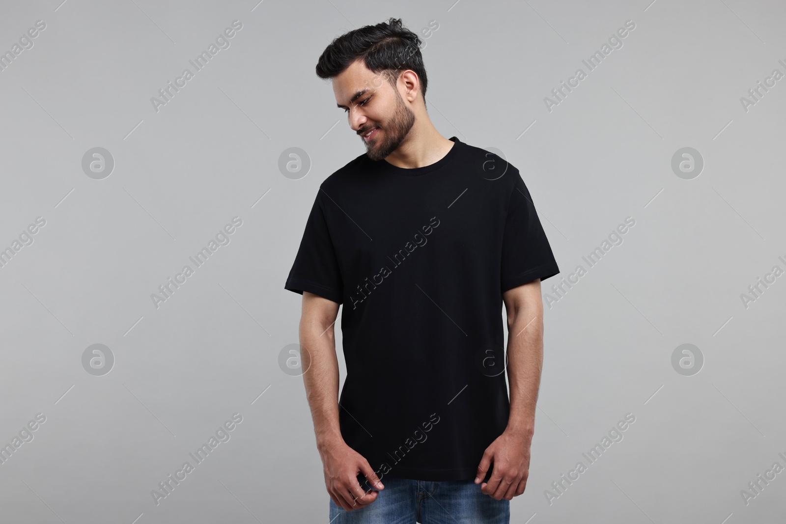 Photo of Smiling man in black t-shirt on grey background