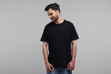 Smiling man in black t-shirt on grey background