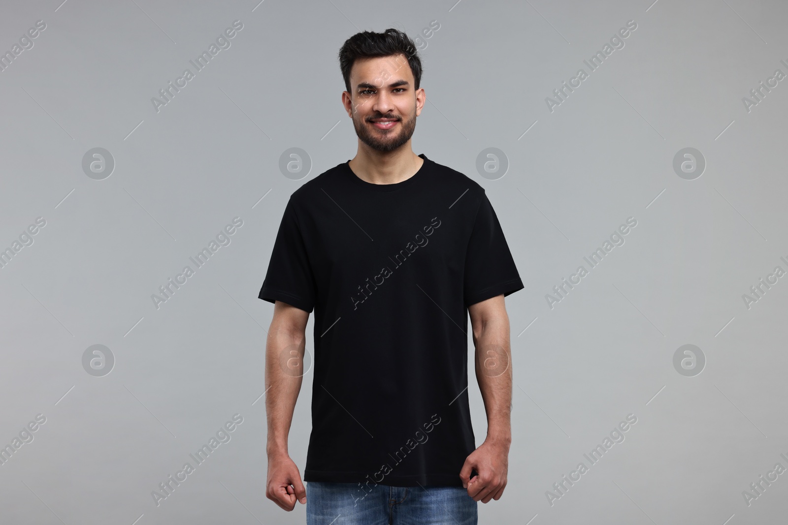 Photo of Smiling man in black t-shirt on grey background