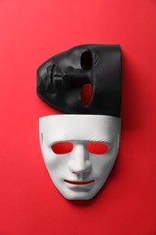 Photo of Theater arts. White and black masks on red background, top view