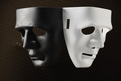 Theater arts. Black and white masks on honeycomb grid, top view