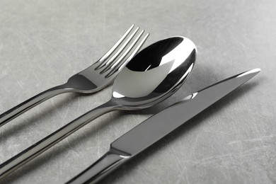 Photo of Stylish silver cutlery set on grey table, closeup