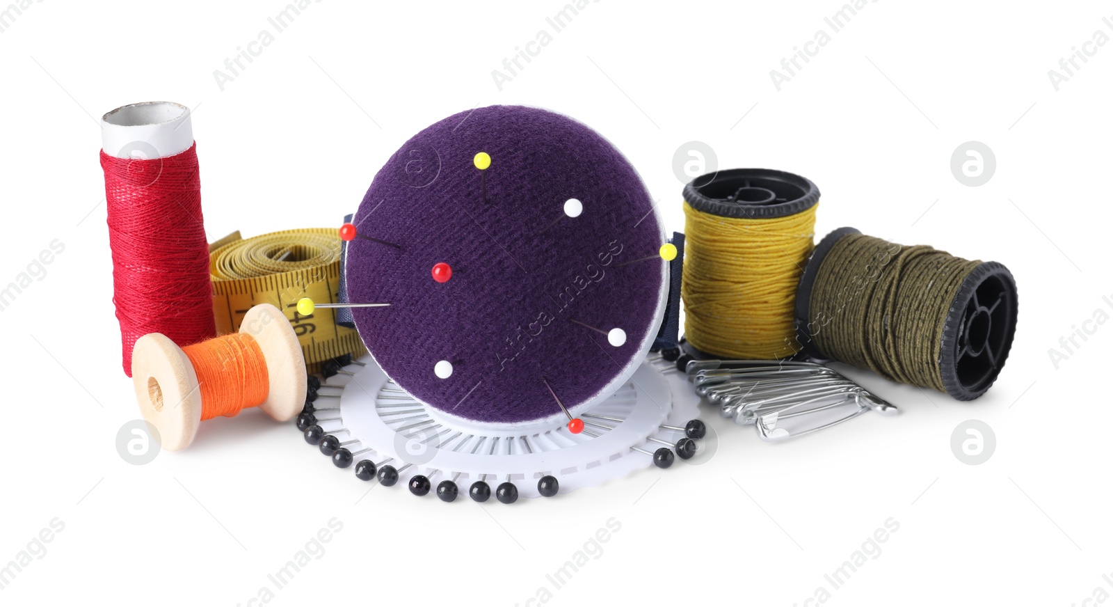 Photo of Pincushion, pins and other sewing tools isolated on white