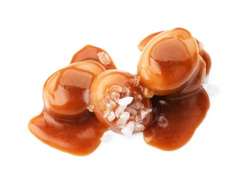 Yummy candies with caramel sauce and sea salt isolated on white, top view
