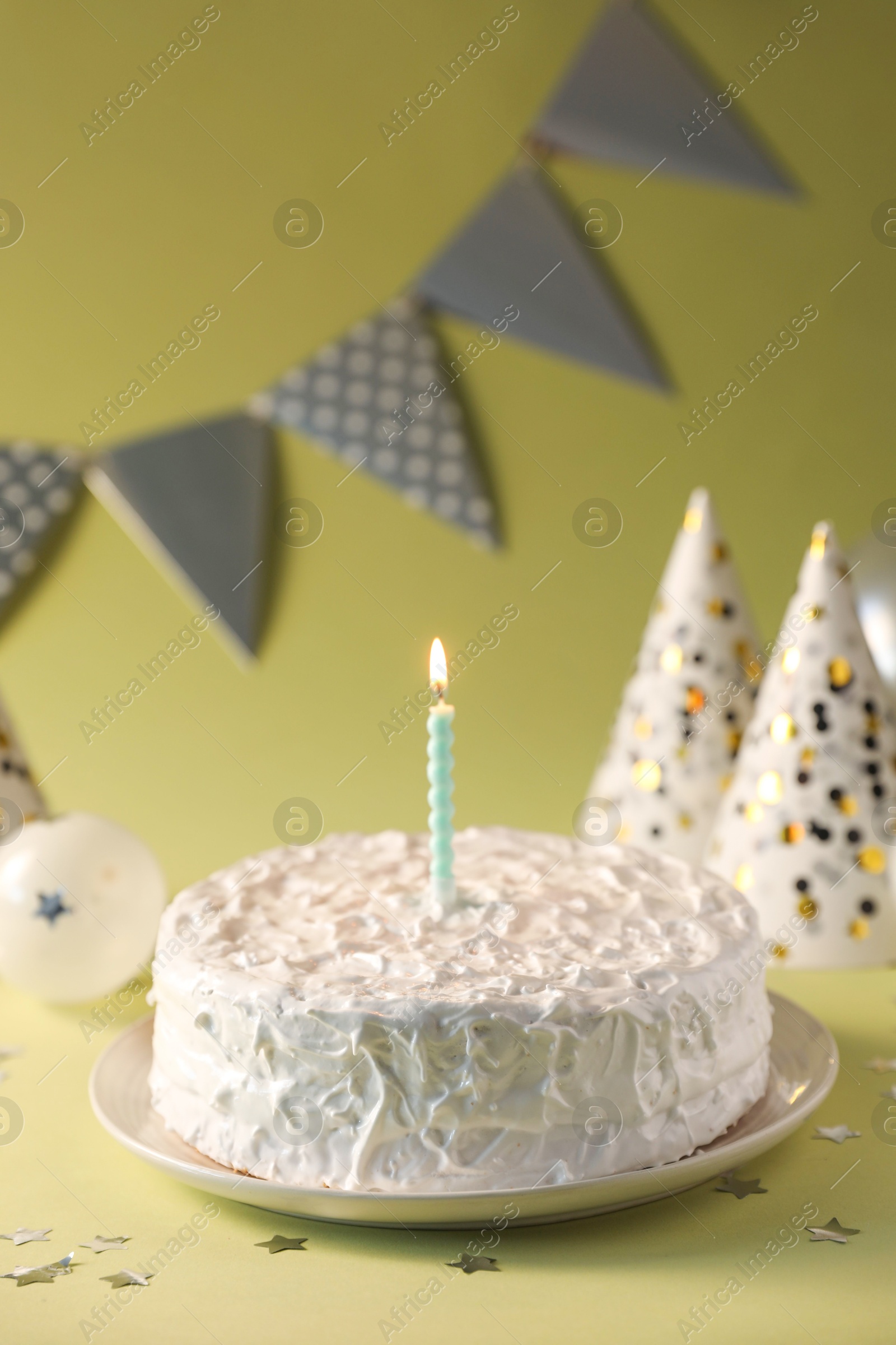 Photo of Tasty cake with burning candle on green background