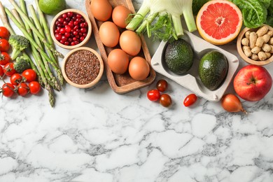 Photo of Many different healthy food on light marble table, flat lay. Space for text