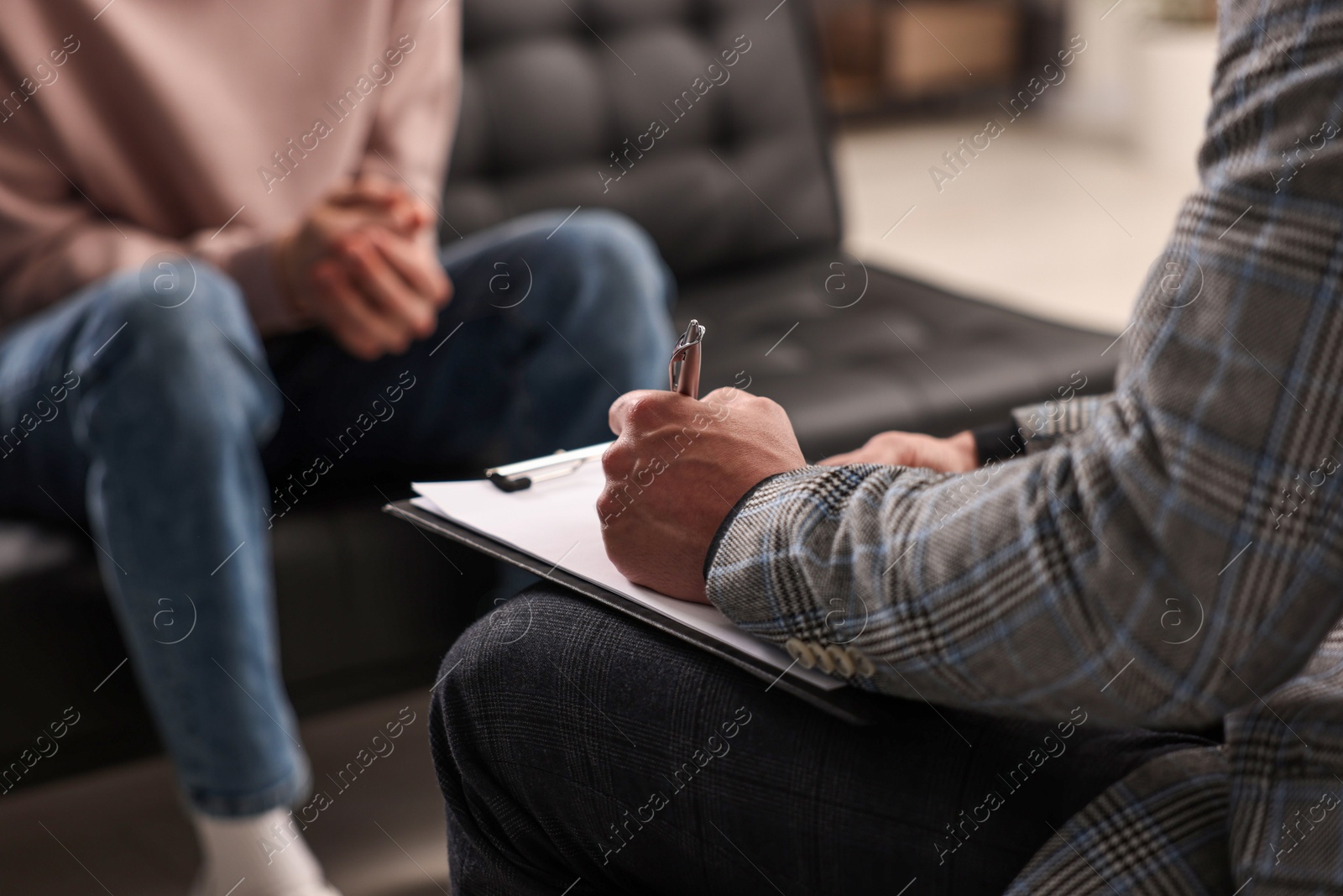 Photo of Professional psychotherapist working with patient in office, closeup