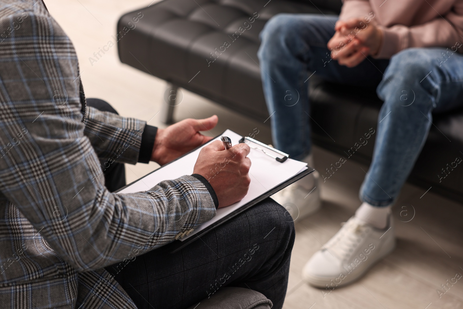 Photo of Professional psychotherapist working with patient in office, closeup