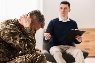 Professional psychotherapist working with military man in office