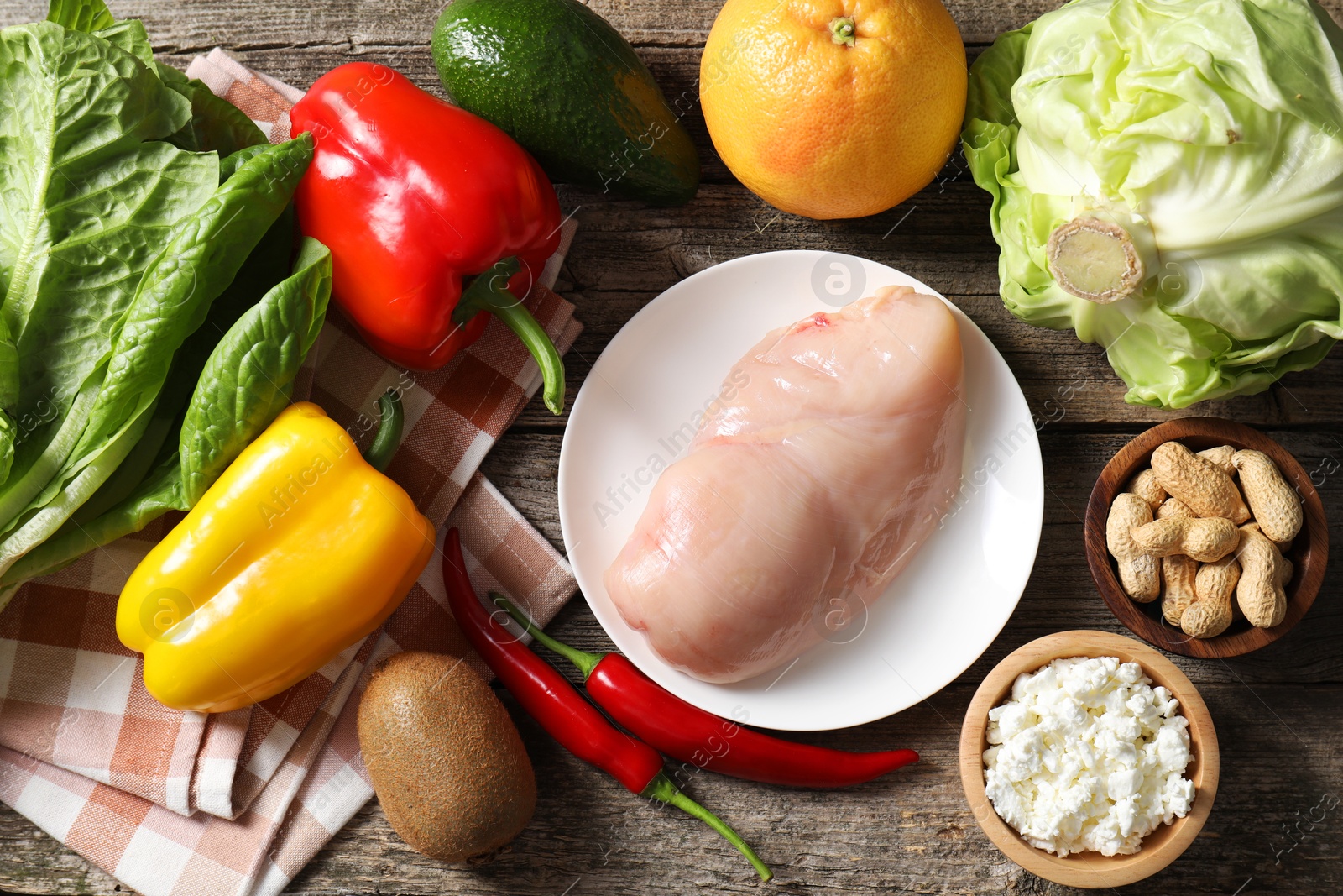 Photo of Healthy meal. Different vegetables and raw chicken breast on wooden table, flat lay