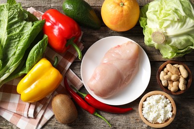 Healthy meal. Different vegetables and raw chicken breast on wooden table, flat lay