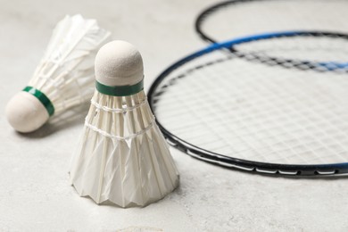 Feather badminton shuttlecocks and rackets on gray background, closeup