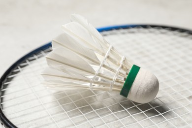 Photo of Feather badminton shuttlecock and racket on gray background, closeup