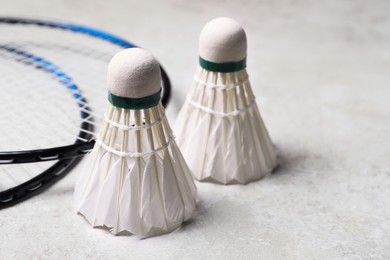 Feather badminton shuttlecocks and rackets on gray background, closeup