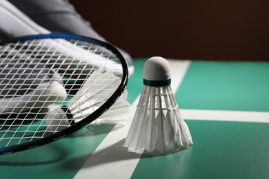 Photo of Feather badminton shuttlecocks and racket on court, closeup