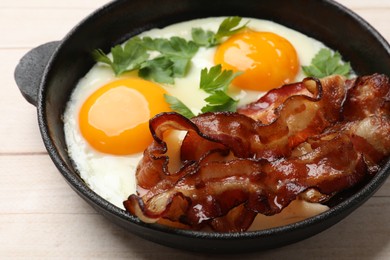 Photo of Tasty bacon, eggs and parsley on light wooden table, closeup