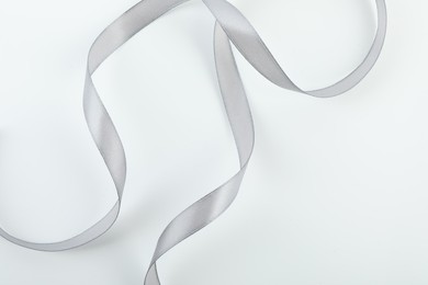 Photo of Beautiful gray ribbon isolated on white, top view