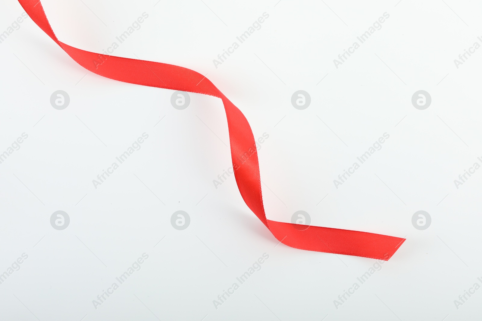 Photo of Beautiful red ribbon isolated on white, top view