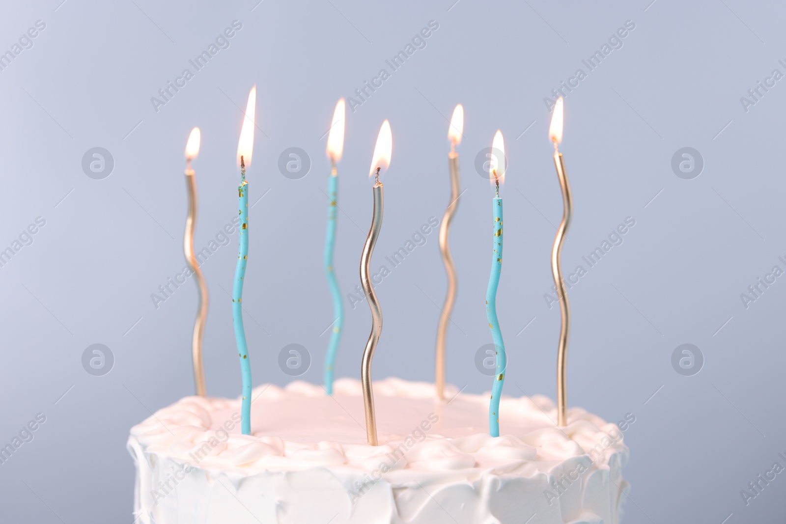 Photo of Tasty Birthday cake with burning candles on gray background, closeup