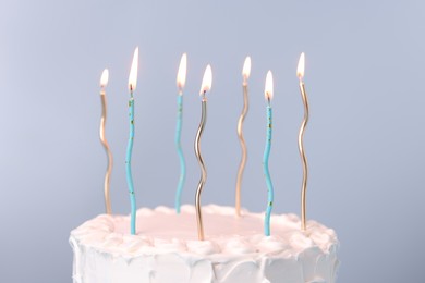 Tasty Birthday cake with burning candles on gray background, closeup